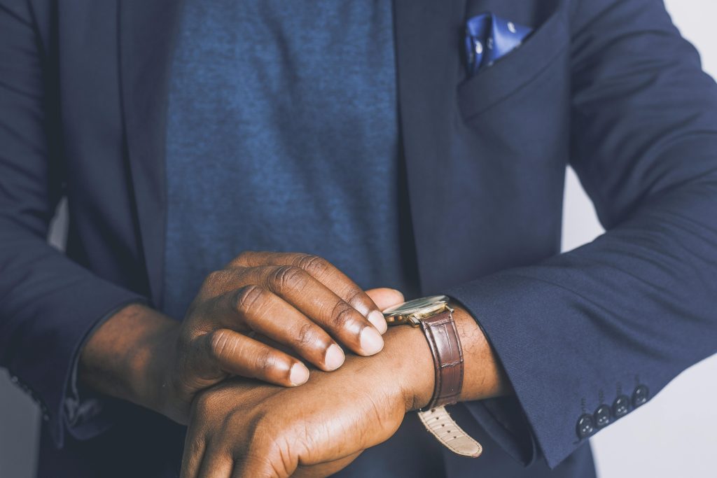 A close-up of a man in a suit checking his wristwatch, showcasing business fashion.
